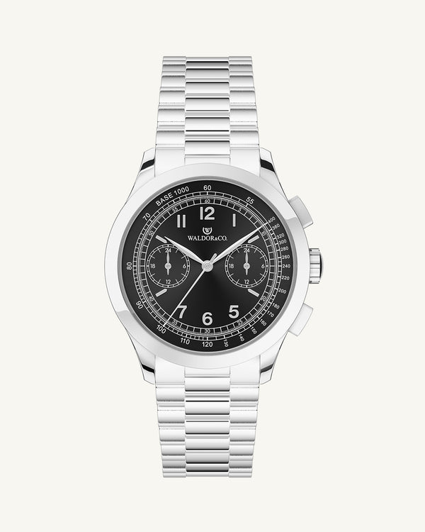 En rund herrklocka i rodiumpläterat silver från WALDOR & CO. med svart sunray urtavla och en sekundvisare. Seiko urverk. Modellen är Chrono 39 Porto Cervo.