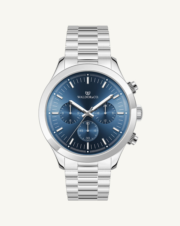 En rund herrklocka i rodiumpläterat silver från WALDOR & CO. med blå sunray urtavla och en sekundvisare. Seiko urverk. Modellen är Chrono 44 Como 44mm.