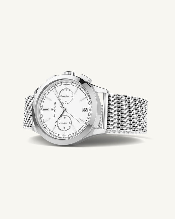 En rund herrklocka i rodiumpläterat silver från WALDOR & CO. med vit sunray urtavla och en sekundvisare. Seiko urverk. Modellen är Chrono 44 Sardinia 44mm.