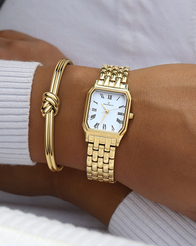 A square womens watch in 22k gold from Waldor & Co. with white Diamond Cut Sapphire Crystal glass dial. Seiko movement. The model is Eternal 22 Bellagio.