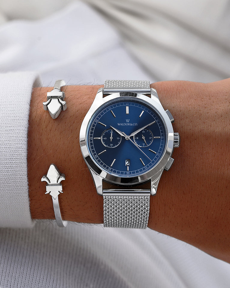  En rund herrklocka i rodiumpläterat silver från WALDOR & CO. med blå sunray urtavla och en sekundvisare. Seiko urverk. Modellen är Chrono 44 Sardinia 44mm. 