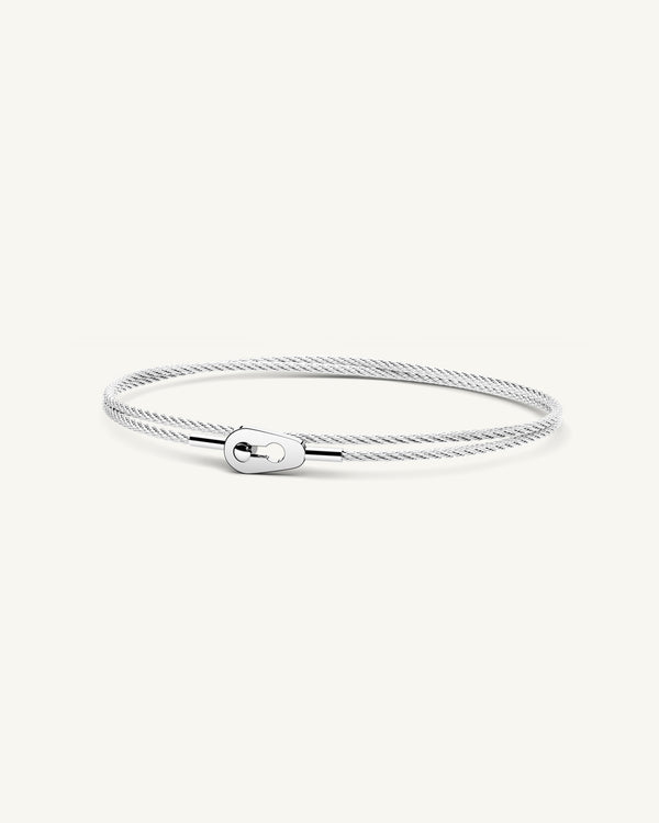 A polished stainless steel bangle in silver from Waldor & Co. One size. The model is Como Bangle Dual Polished