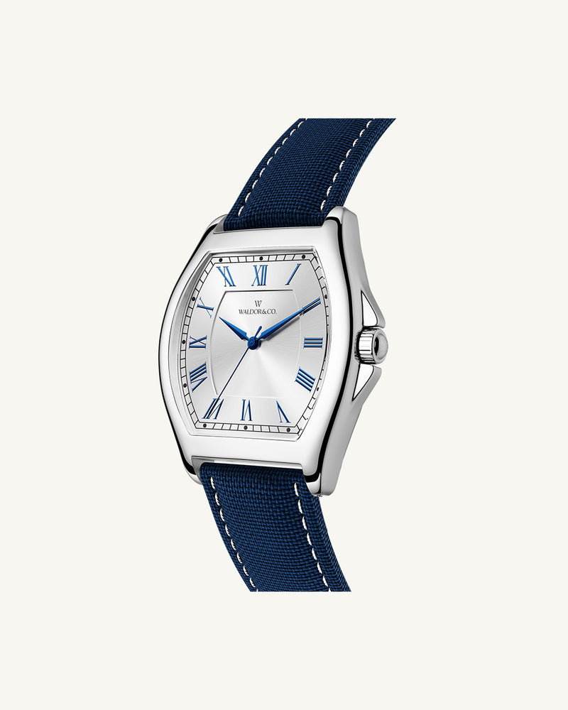 A square mens watch in Rhodium-plated 316L stainless steel from Waldor & Co. with white dial. Blue sailcloth strap. Ronda movement. The model is Constant 40 Tremezzo 37x45mm.