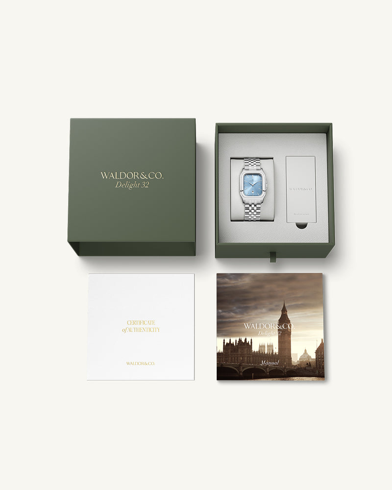 A square womens watch in silver and 14k gold from Waldor & Co. with light blue sunray dial and a second hand. Seiko movement. The model is Delight 32 Chelsea 28x32mm.