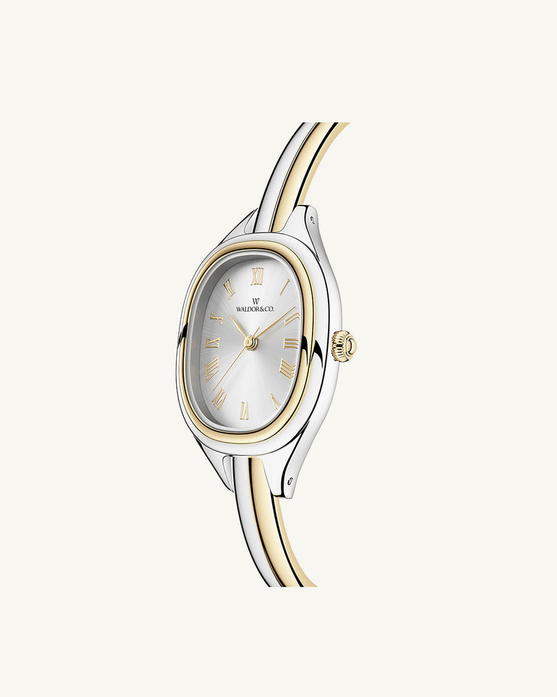 An ellipse shaped womens watch in Rhodium-plated 316L stainless steel from Waldor & Co. with silver sunray dial in brass. Mineral glass with sapphire crystal coating. Seiko movement. The model is Dual Bangle Watch.