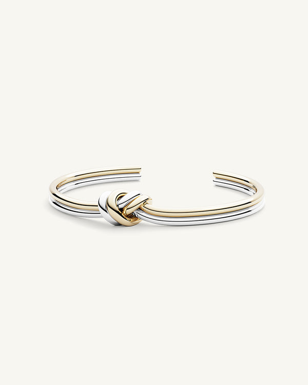 A Bangle in 14k-gold plated and silver polished 316L stainless steel from Waldor & Co. One size. The model is Dual Knot Bangle Polished.