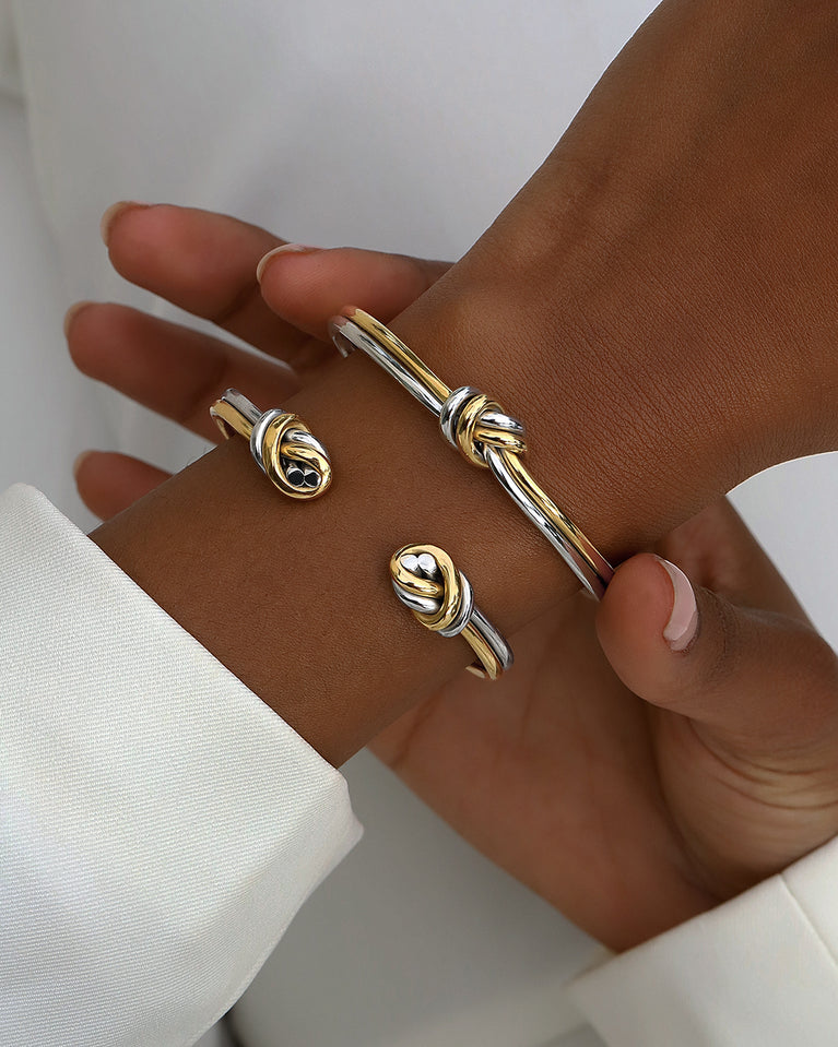 A Bangle in 14k-gold plated and silver polished 316L stainless steel from Waldor & Co. One size. The model is Dual Knot Twin Bangle Polished.