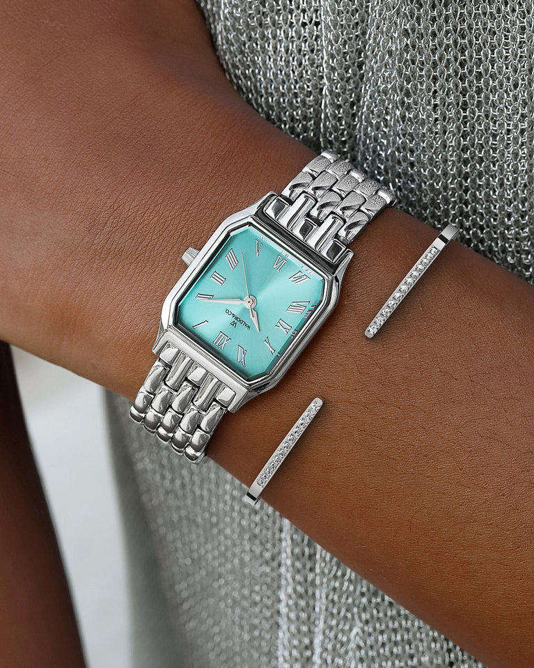 A square womens watch in Rhodium-plated 316L stainless steel from Waldor & Co. with turquoise Diamond Cut Sapphire Crystal glass dial. Seiko movement. The model is Eternal 22 Bellagio.