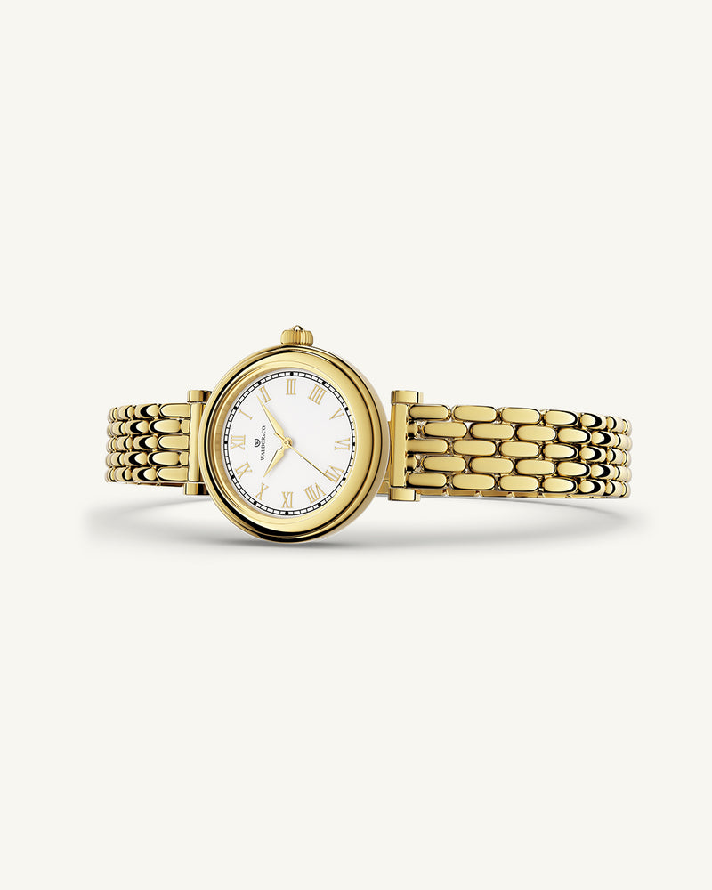 A round womens watch in 22k gold plated 316L stainless steel from Waldor & Co. with white Sapphire Crystal glass dial. Seiko movement. The model is Venia 24 Villefranche.