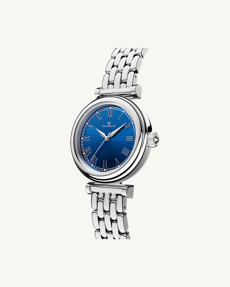 A round womens watch in Rhodium-plated 316L stainless steel from Waldor & Co. with blue Sapphire Crystal glass dial. Seiko movement. The model is Venia 24 Villefranche.