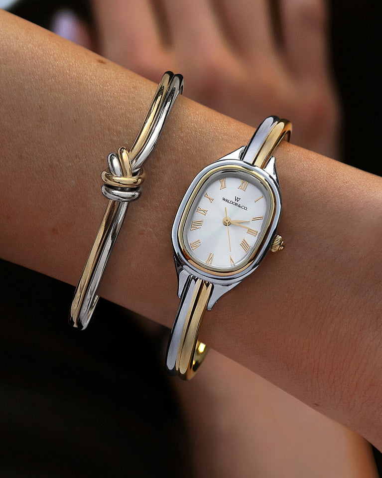  An ellipse shaped womens watch in Rhodium-plated 316L stainless steel from Waldor & Co. with silver sunray dial in brass. Mineral glass with sapphire crystal coating. Seiko movement. The model is Dual Bangle Watch.